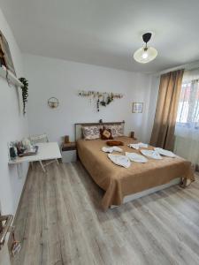 1 dormitorio con 1 cama grande en una habitación con suelo de madera en Happy Home, en Călimăneşti