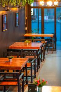 - une rangée de tables et de chaises en bois dans un restaurant dans l'établissement Black Panther Hostel, à Phuket