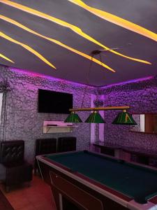 a pool table in a room with purple lighting at Villa5floors in Chişinău