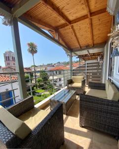 een patio met stoelen en een tafel op een balkon bij Delia Apartments in Pefkochori