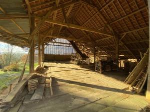 a large barn with a wooden floor and a roof at la maison de Manon in Mirande