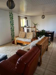 sala de estar con sofá, sofá y mesa en La case ludovic en Le Tampon