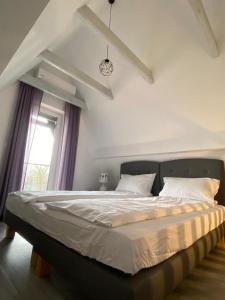 a large bed in a bedroom with a window at Lawendowa Przystań in Wielen Zaobrzanski