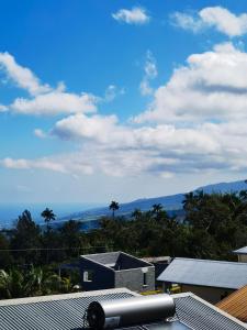 a view of the mountains from the roof of a house at La case ludovic in Le Tampon