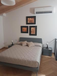 ein Schlafzimmer mit einem Bett und drei Bildern an der Wand in der Unterkunft CA' DE BERTO in Valcarecce
