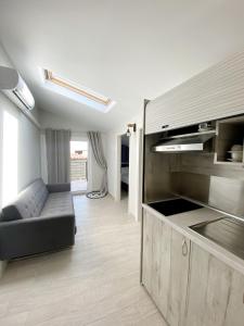 een woonkamer met een bank en een keuken bij Delia Apartments in Pefkochori