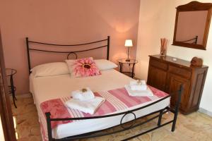sypialnia z łóżkiem z ręcznikami i lustrem w obiekcie Plaza w mieście Giardini Naxos