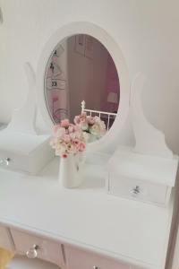 a white dressing table with a mirror and flowers in a vase at Nina in Baška Voda +32 photos