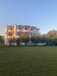 a large apartment building with a field in front of it at Casa Gazi in Ulcinj
