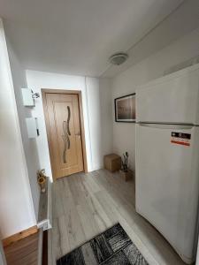 a living room with a refrigerator and a door at Casa Corina in Vişeu de Sus