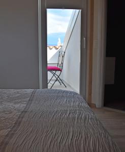 Habitación con 1 cama y 1 silla en el balcón. en Villa Stagnja, en Split
