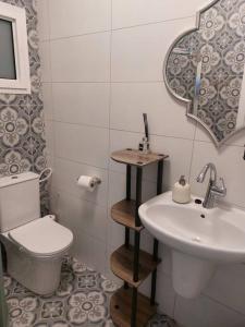 a bathroom with a sink and a toilet and a mirror at הבית ליד הבוסתן in Mikhmannim