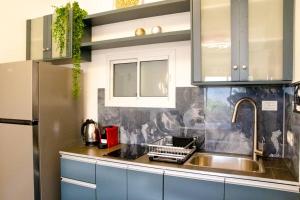 una cucina con lavandino e frigorifero in acciaio inossidabile di הבית ליד הבוסתן a Mikhmannim