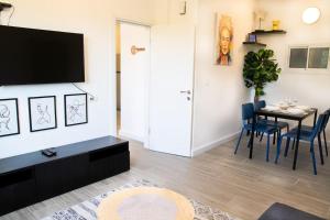 a living room with a table and a tv on a wall at הבית ליד הבוסתן in Mikhmannim