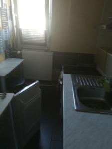 een kleine keuken met een wastafel en een raam bij Fitness Pension in Sulingen