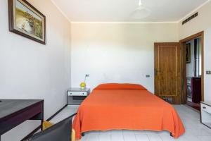 una camera con un letto e una coperta arancione di Casa Velio a Castiglione della Pescaia