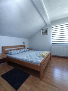 Schlafzimmer mit einem Bett und einem Fenster in der Unterkunft Guesthouse Nikolina in Korenica