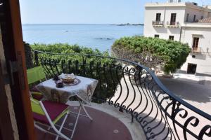 balkon ze stołem i widokiem na ocean w obiekcie Plaza w mieście Giardini Naxos