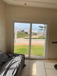 a bedroom with a sliding glass door with a view of the ocean at Sidi Bouzid Ground floor with garden and swim pool see view in Sidi Bouzid