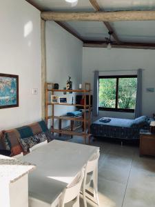 a living room with a table and a couch at Suites surf house itamambuca in Ubatuba