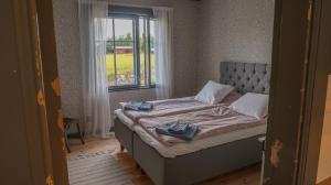 Cama en habitación con ventana en Lillstugans Gästhem BnB, en Vöyri