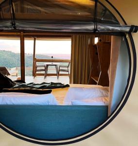 Bett in einem Zimmer mit Aussicht in der Unterkunft Glamping - Il Giardino di San Giorgio in Montorgiali