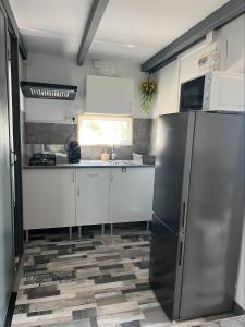 a kitchen with a stainless steel refrigerator and white cabinets at Chalet Espagne EL FARO 4/6p in Camarles
