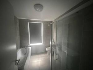 ein Bad mit einer Dusche, einem WC und einem Fenster in der Unterkunft 5 Bed, easy access to Stratford/Central London in London
