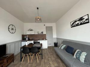 sala de estar con sofá y mesa en Appartement F1, refait à neuf, 150m de la plage, en Donville-les-Bains