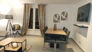 a living room with a table and chairs and a couch at Appartement dans un pavillon in Orange
