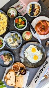 a table full of plates of food with eggs at Savoy Sea Side Hotel in Tel Aviv