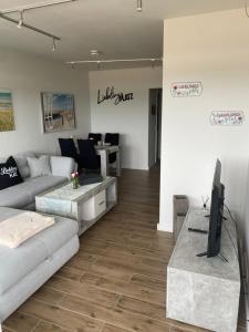 uma sala de estar com um sofá e uma televisão em Ferienwohnung Lieblingsplatz em Sierksdorf