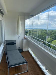 einen Stuhl in einem Zimmer mit großen Fenstern in der Unterkunft Ferienwohnung Lieblingsplatz in Sierksdorf