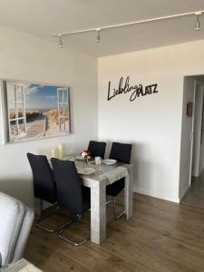 a dining room with a table and black chairs at Ferienwohnung Lieblingsplatz in Sierksdorf