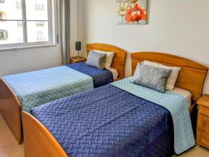 a bedroom with two beds with blue comforters at Two Bedroom Apartment - 110m2, AC, Terrace, Wi-Fi in Lagos