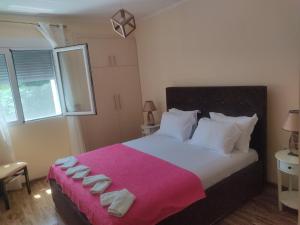 a bedroom with a large bed with a pink blanket at Apartman Rijeka Crnojevica in Rijeka Crnojevića