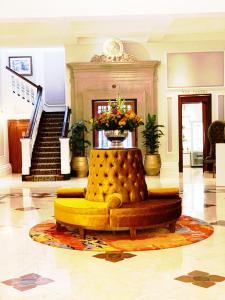 a yellow couch in a lobby with a staircase at Taj Cape Town - private luxury 5 star suites - very spacious with kitchenette in Cape Town