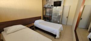 a hospital room with two beds and a television at Sleep Suites in Belo Horizonte