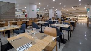 a restaurant with wooden tables and blue chairs at Hotel AF Valle Orotava in Puerto de la Cruz