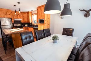 una cocina con mesa y sillas y una cocina con armarios de madera. en Le 583 Stoneham CITQ#239,960, en Stoneham