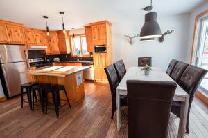 a kitchen with a table and chairs and a kitchen with wooden cabinets at Le 583 Stoneham CITQ#239,960 in Stoneham