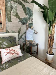 a bedroom with a bed and a plant on the wall at LA PLAGE in La Grande-Motte