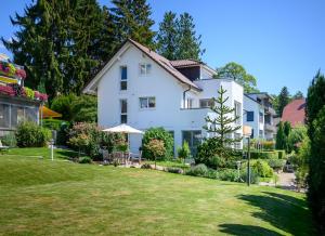 duży biały dom z ogródkiem w obiekcie Röther Gesundheitszentrum Bodensee w mieście Überlingen