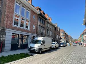 une camionnette blanche garée sur le côté d'une rue dans l'établissement Gîtes de Tournai - Les carrières, à Tournai