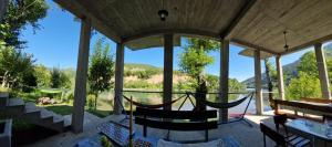 a porch with a hammock and a view at Vikendica pored Drine Foča in Handići