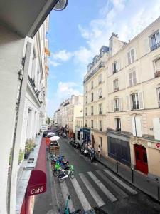 a view of a city street with buildings and motorcycles at T2 Sacré Cœur - Butte Montmartre - Abbesses in Paris
