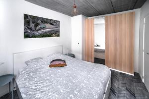 Gîtes de Tournai - Les carrières في تورناي: غرفة نوم عليها سرير ومخدة
