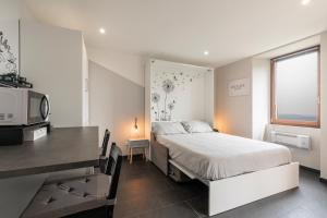 a bedroom with a bed and a desk and a microwave at Casa Belvedere Egro - tiny house in Cesara