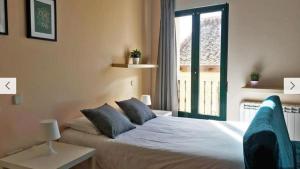 een slaapkamer met een bed en een groot raam bij Estudio en Centro de Segovia in Segovia