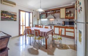 uma cozinha com uma mesa e cadeiras e um frigorífico em Gorgeous Apartment In Santa Maria Capua Vete With Wifi em Santa Maria Capua Vetere